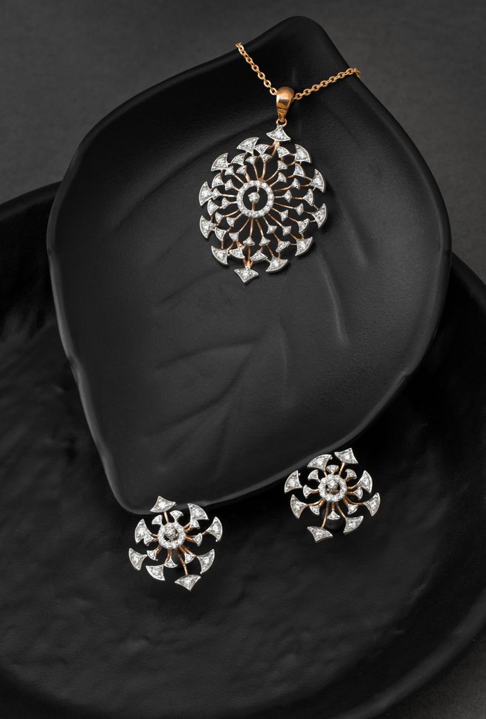 Mastering the First Impression: Your intriguing post title goes here Luxurious gold and diamond jewelry set featuring a pendant and earrings on a black leaf-shaped surface.